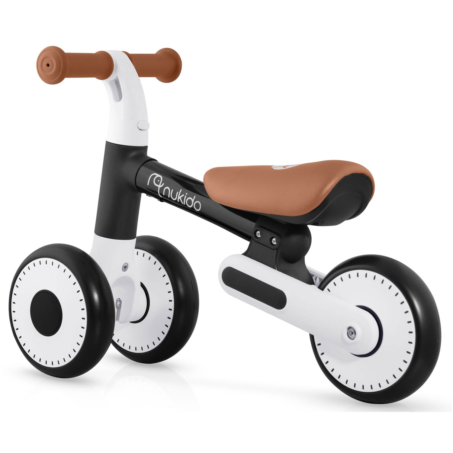 Una bicicleta de equilibrio para niños pequeños. Tiene un asiento y puños marrones, cuadro y ruedas blancos y negros. La marca Nukido es visible.