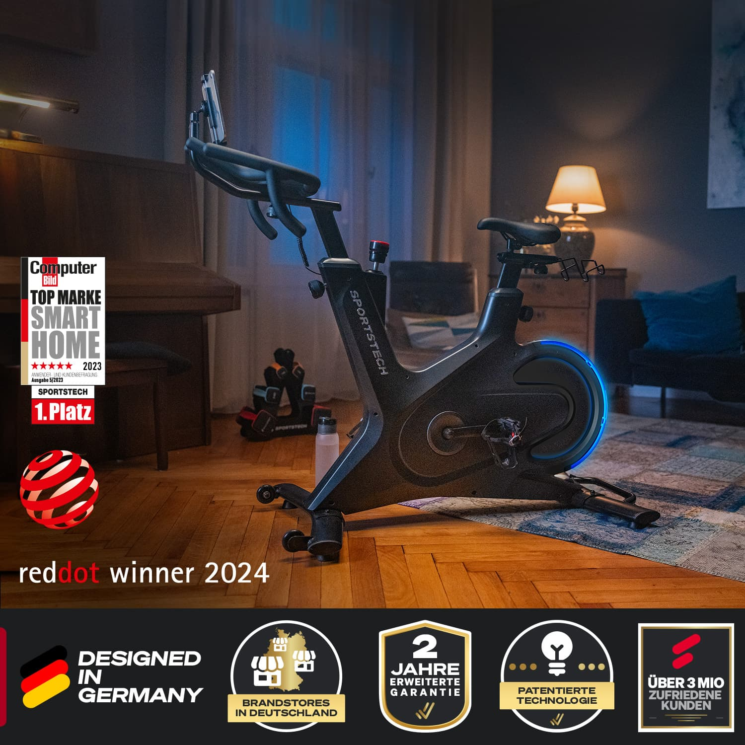 Indoor-Heimtrainer in einem Raum. Er hat ein digitales Display, Auszeichnungen auf der linken Seite und ein Logo auf dem Fahrrad und die Worte "red dot winner 2024".