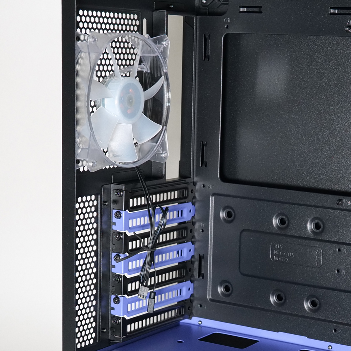 All'interno di un case di computer: una ventola trasparente, alloggiamenti blu e un interno nero. I fili sono visibili e il case è parzialmente aperto.