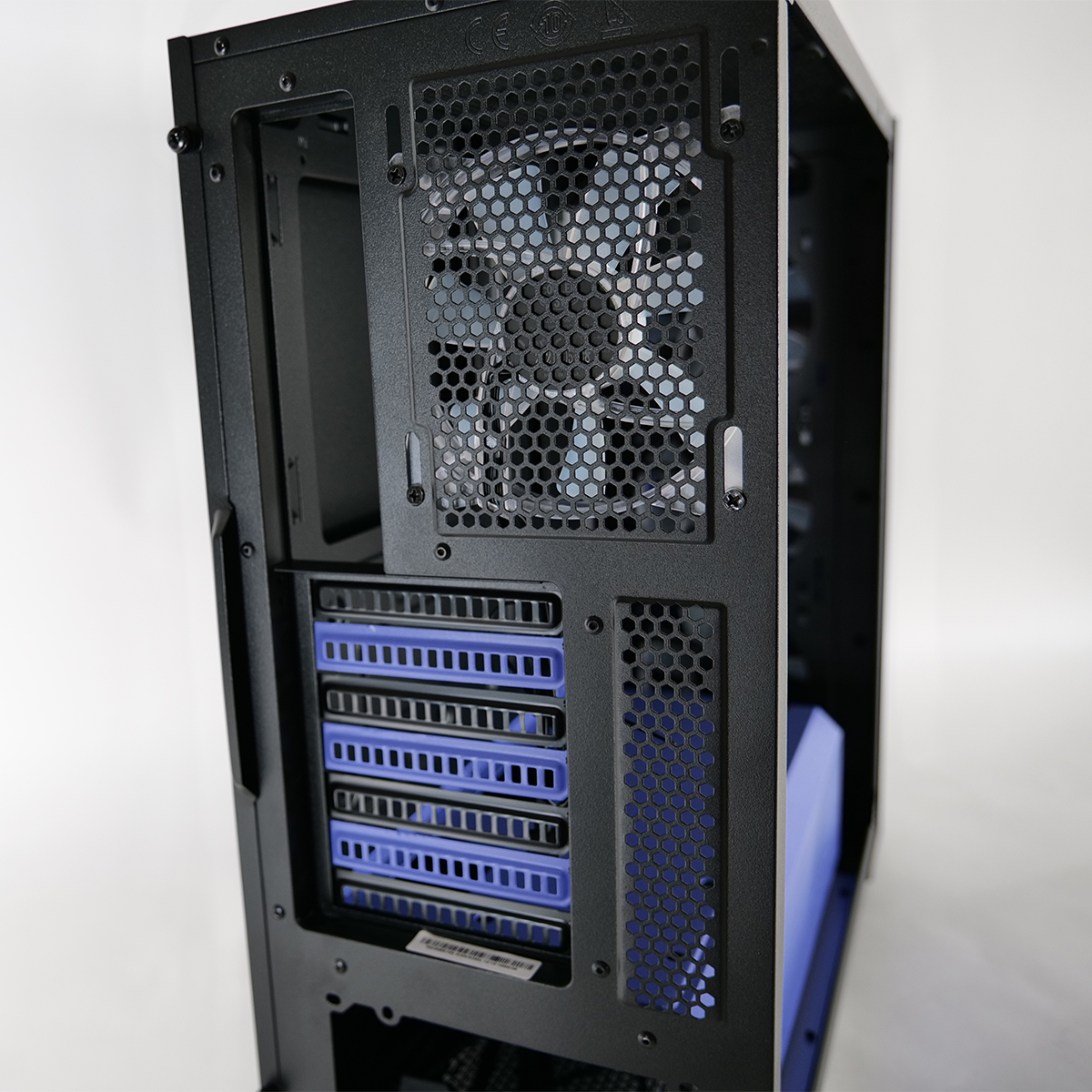 Interno nero di un case per computer con componenti blu. Sono visibili una ventola, prese d'aria e alloggiamenti. Lo sfondo è bianco.