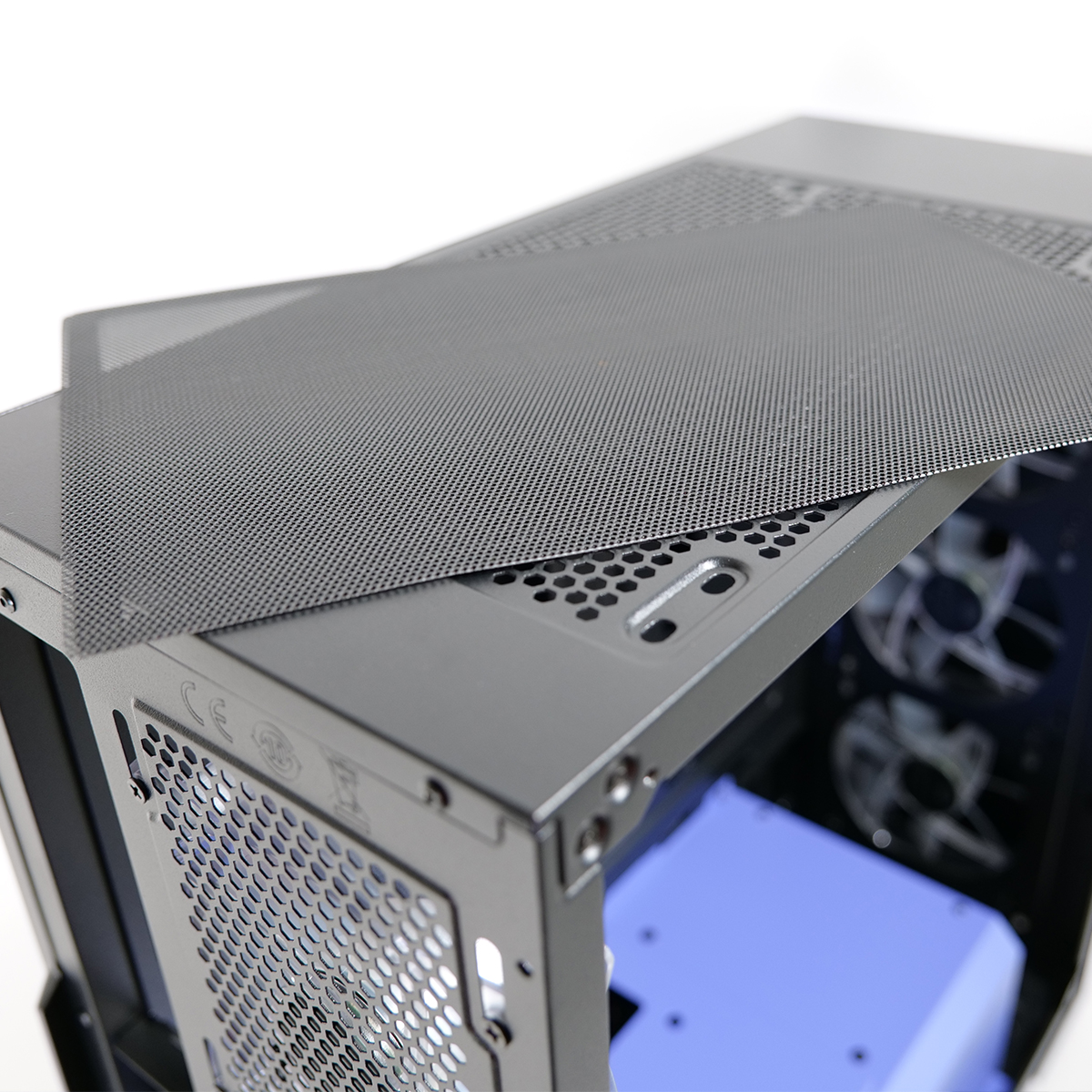 Un case per computer con un pannello a rete sulla parte superiore, che rivela l'interno. L'involucro è grigio, e la rete è grigio scuro.