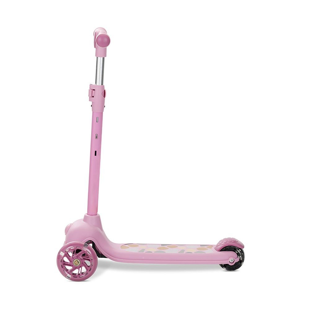 Un patinete rosa con tres ruedas, un manillar y una plataforma con un diseño, sobre un fondo blanco.