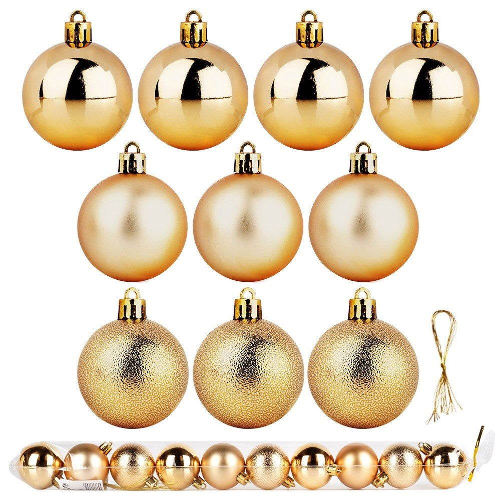 Una colección de adornos navideños dorados. Algunos son brillantes, otros mate y otros texturizados. También hay una cuerda y un paquete.