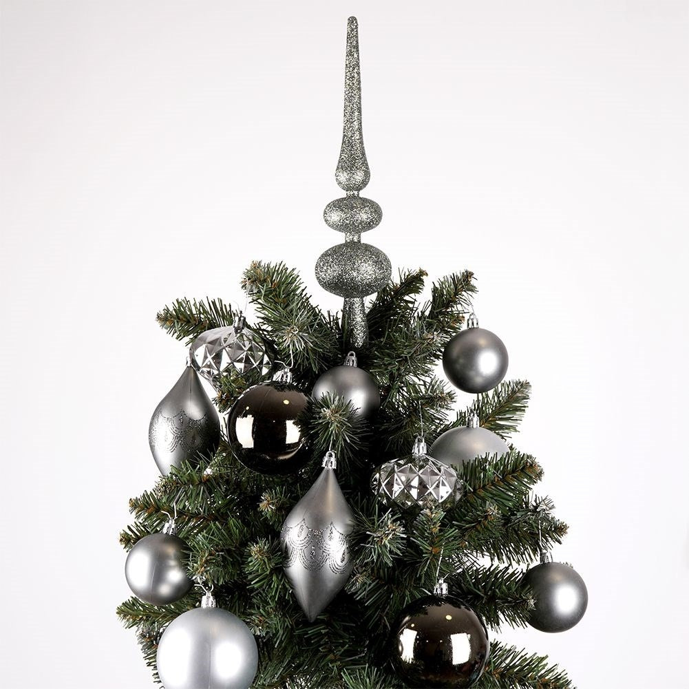 Un árbol de Navidad decorado con adornos plateados y negros. Una punta plateada se encuentra encima del árbol. El fondo es blanco.