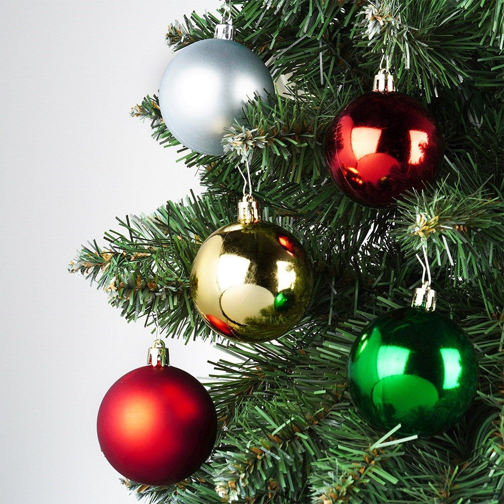 Un árbol de Navidad con adornos plateados, rojos, dorados y verdes. Los adornos son redondos y brillantes, y el árbol es verde.