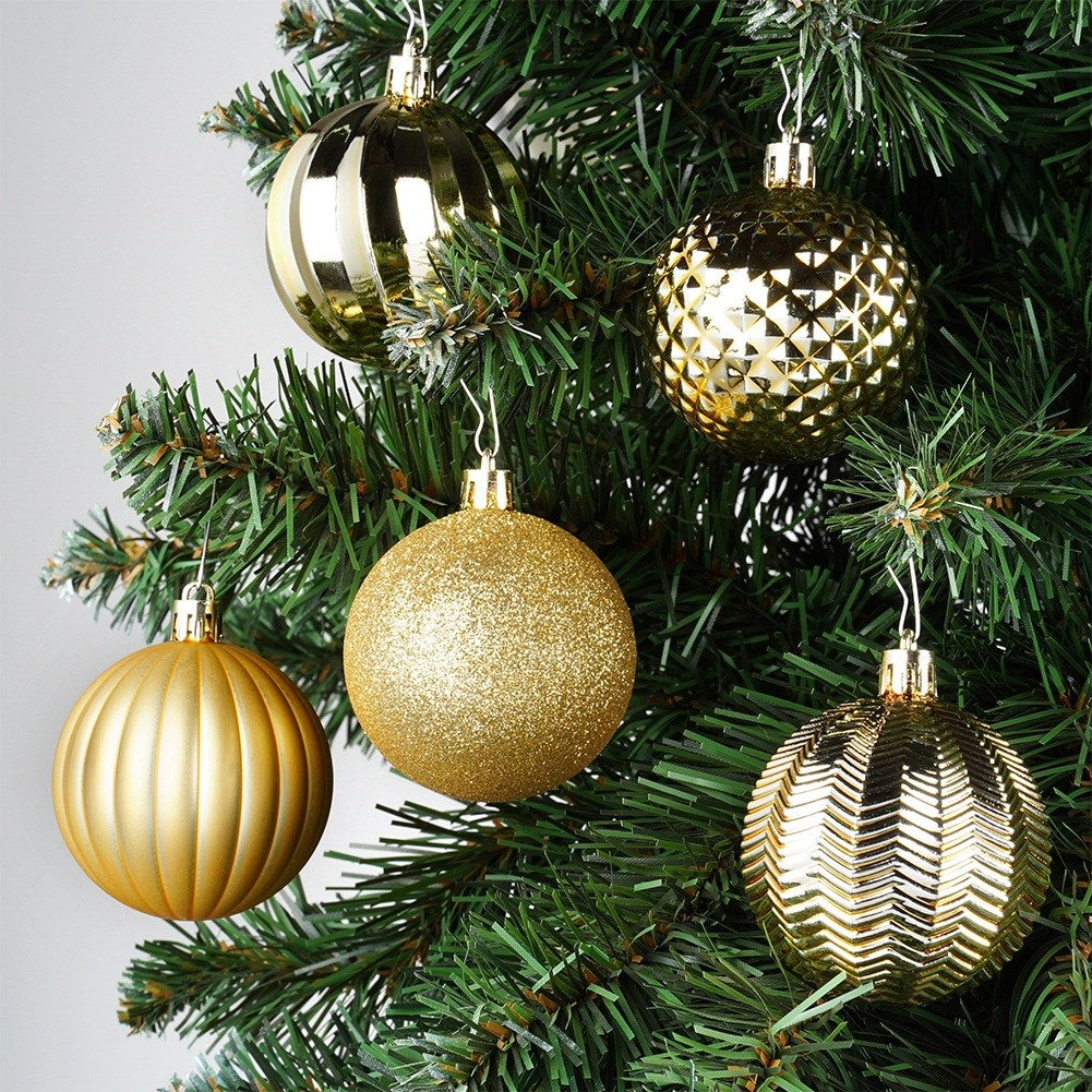 Primer plano de un árbol de Navidad con cinco adornos dorados. Los adornos tienen varias texturas y cuelgan de ganchos plateados.
