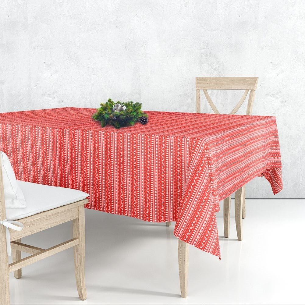 Una mesa de comedor con un mantel rojo estampado, dos sillas de madera y una corona central.