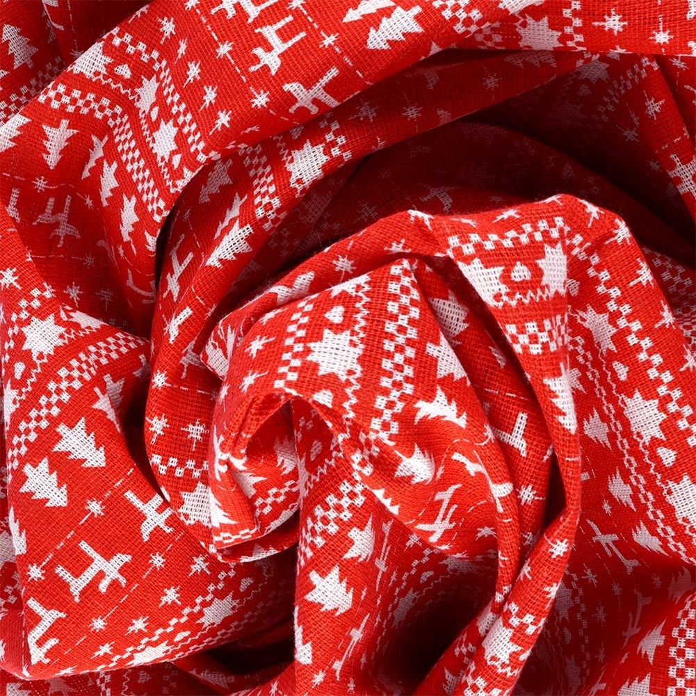 Tela roja con patrones blancos de copos de nieve, árboles y formas geométricas. La tela está doblada.