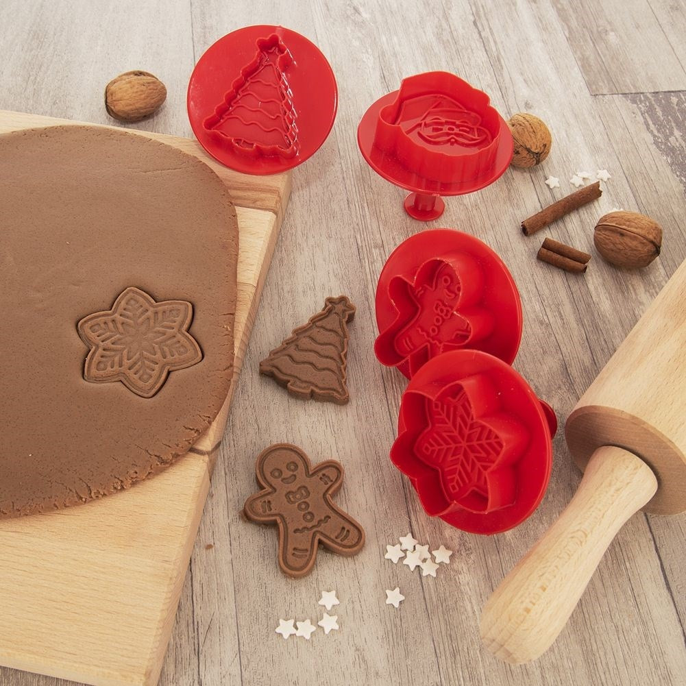 Cortadores de galletas navideñas y masa. Incluye un árbol, copo de nieve, hombre de jengibre y Papá Noel. También nueces y canela.