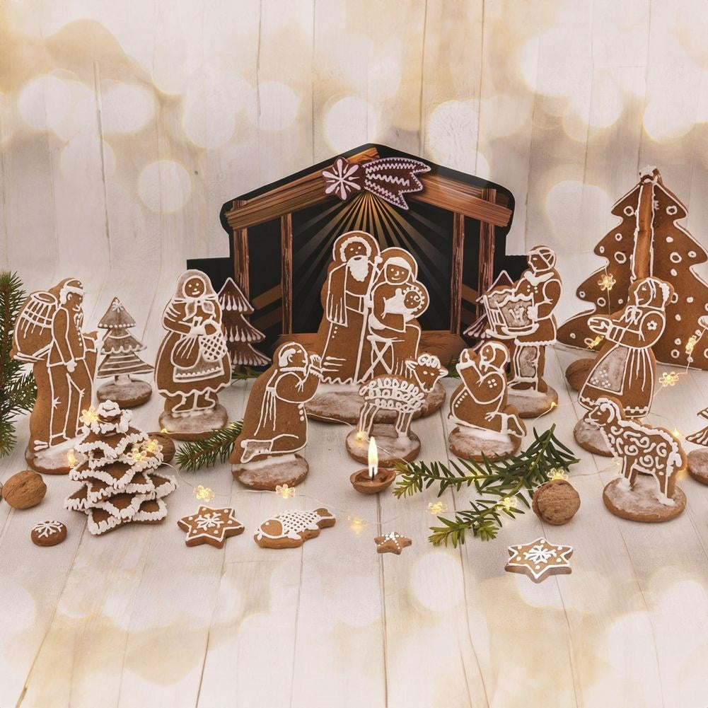 Escena de Navidad de pan de jengibre con figuras, árbol, galletas de estrella y una vela. Las figuras incluyen a María, José y el niño Jesús.