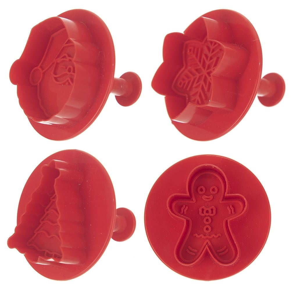 Cuatro cortadores de galletas rojos: Papá Noel, copo de nieve, árbol de Navidad y hombre de jengibre, cada uno con mango, sobre fondo blanco.