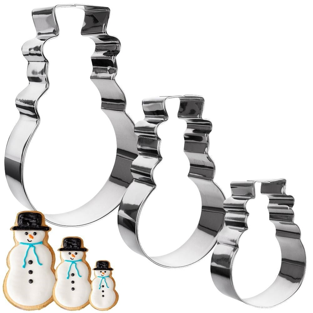 Tres cortadores de galletas con forma de muñeco de nieve y tres galletas de muñeco de nieve glaseadas. Los cortadores son de tamaños descendentes.