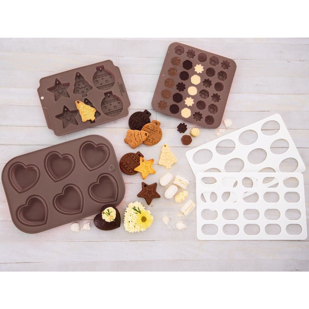 Varios moldes y productos horneados. Formas de corazón, estrella, árbol y bola. Incluye bombones, galletas en forma de estrella y corazón.
