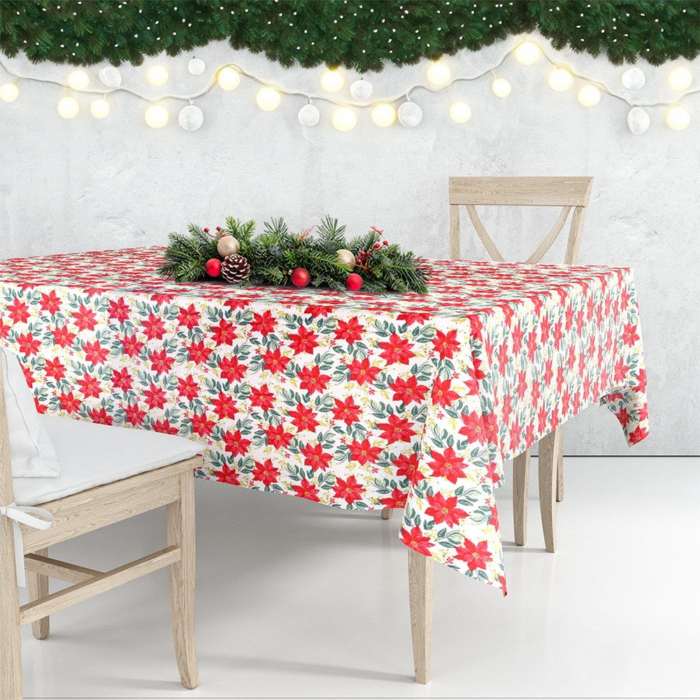 Una mesa para Navidad. Mantel floral rojo, dos sillas de madera y un centro de mesa con pino y adornos.