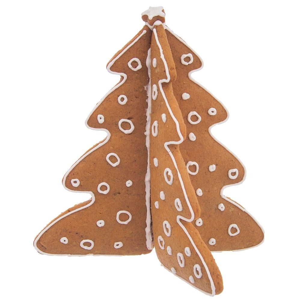 Un árbol de Navidad de pan de jengibre con detalles de glaseado blanco, de pie sobre una superficie blanca. El árbol está hecho de tres partes conectadas.