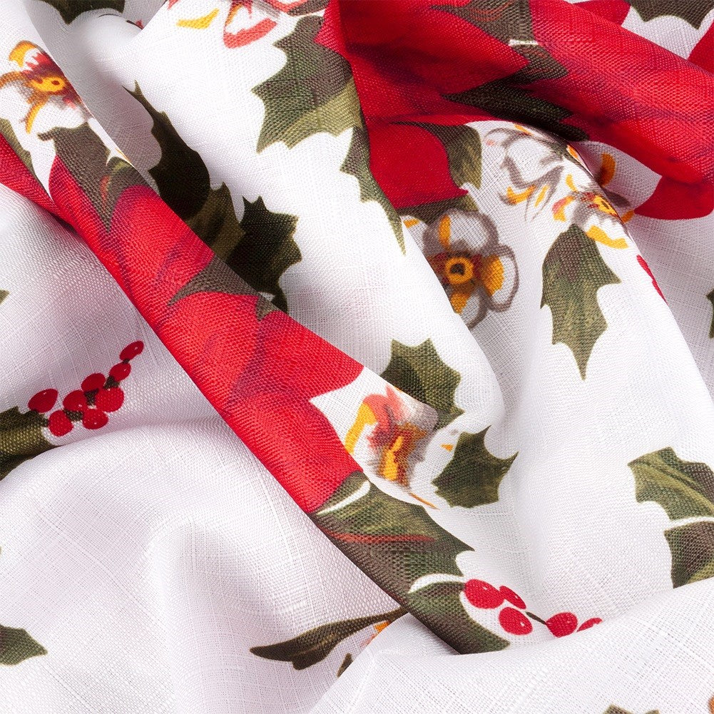 Tela blanca con cintas rojas y hojas verdes. Bayas rojas y patrones florales dispersos por la superficie.