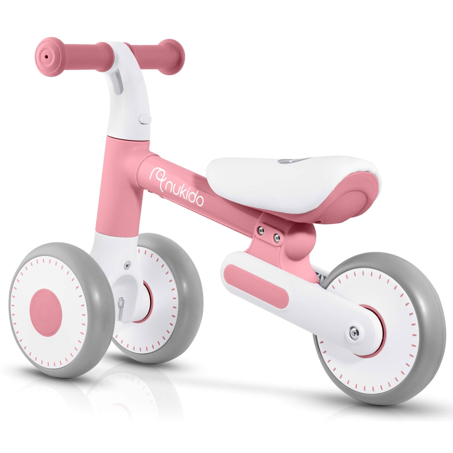 Una bicicleta de equilibrio rosa y blanca para niños pequeños. Tiene dos ruedas delanteras y una trasera. Las ruedas son grises con centros rosas.
