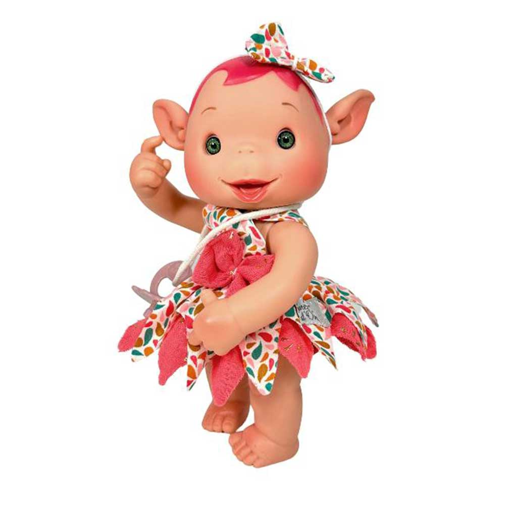 Una muñeca con pelo rosa, vestida con un vestido floral y un lazo, está sonriendo. Tiene orejas grandes y ojos verdes, con un dedo levantado.