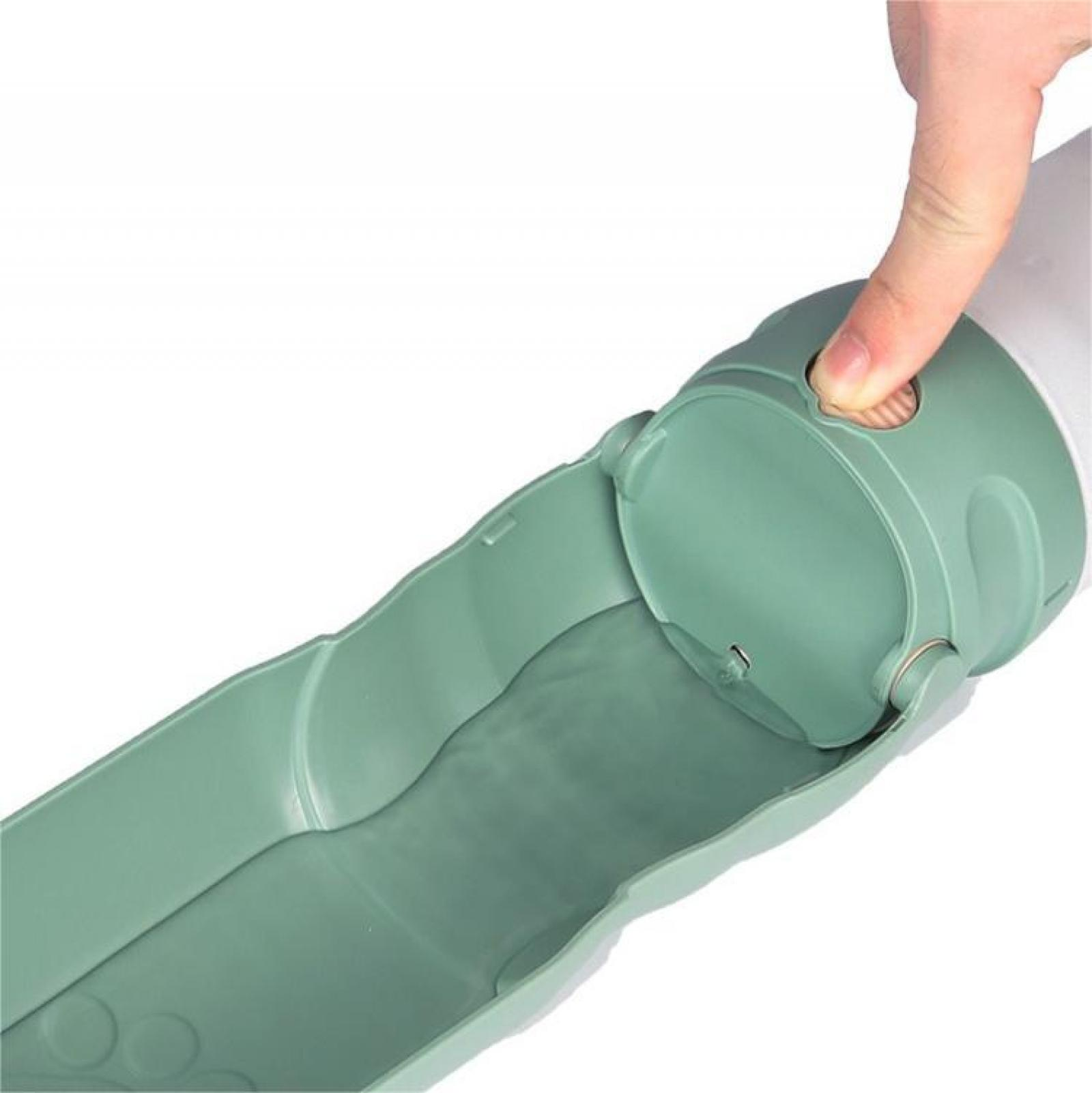 Eine Hand drückt einen Knopf an einem grünen Wasserspender. Der Spender hat eine Rinne und einen weißen Behälter.