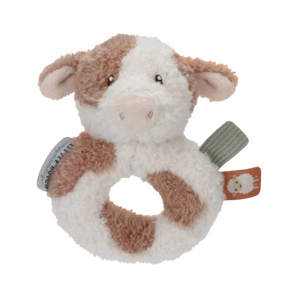 Un sonajero con forma de vaca de peluche. Tiene pelo marrón y blanco, un cuerpo de anillo y etiquetas. Es un juguete para bebés.