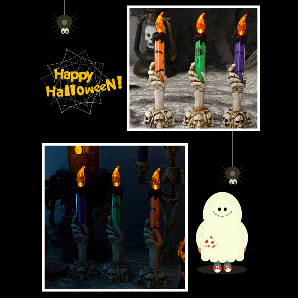 Halloween-Dekoration mit Kerzen, die von Skeletthänden gehalten werden. Eine Spinne und ein Geist sind ebenfalls vorhanden. Die Kerzen sind orange, grün und lila.