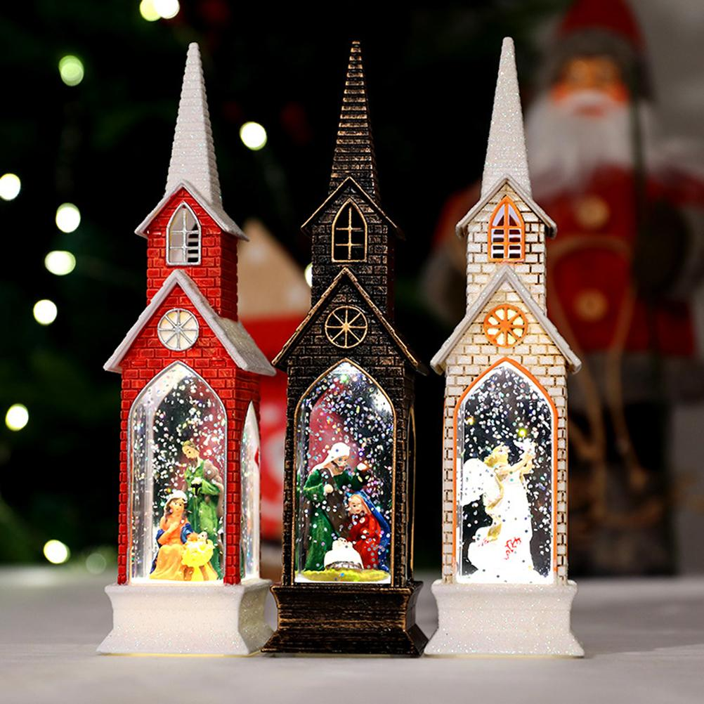 Drei Weihnachts-Schneekugeln in Kirchenform. Rote, schwarze und weiße Backsteinbauten mit Krippenszenen. Im Hintergrund ist der Weihnachtsmann unscharf.
