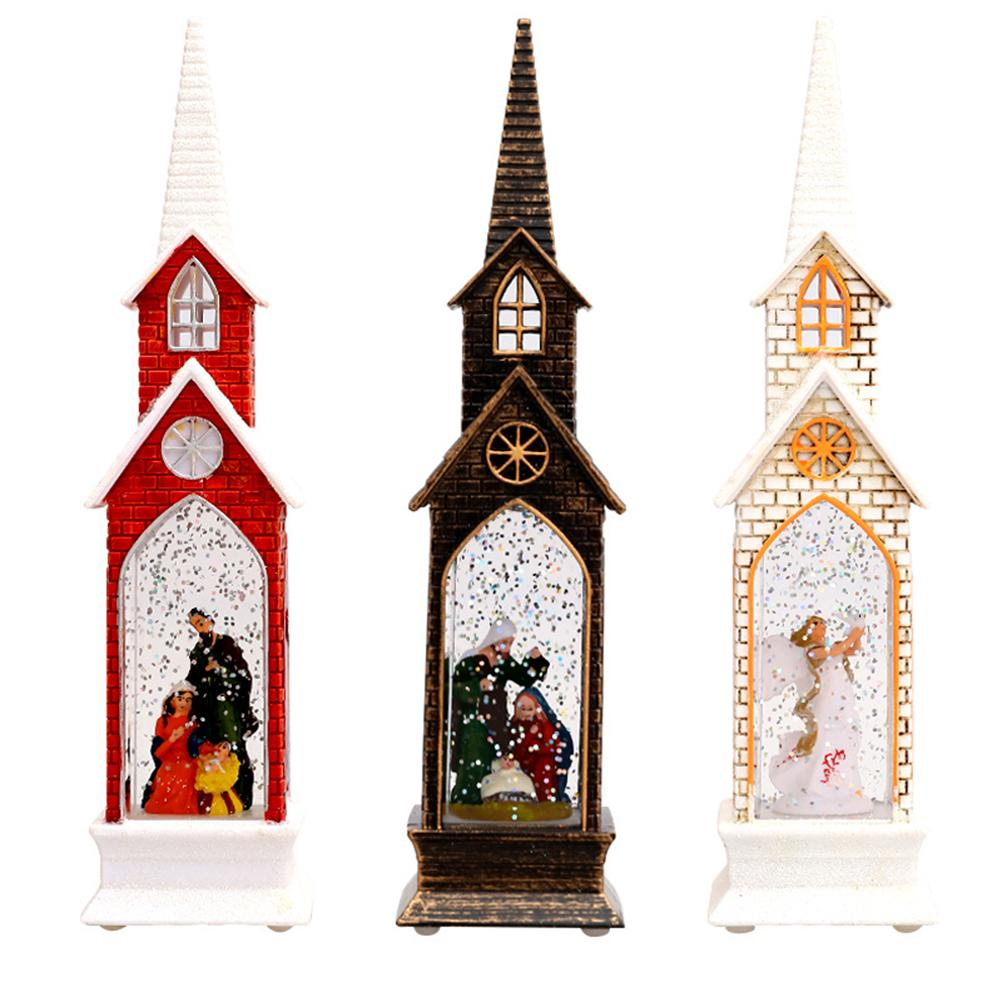 Drei Schneekugeln in Form von Kirchen. Jede hat eine andere Farbe und eine Szene im Inneren. Rot, Braun und Weiß mit Figuren.