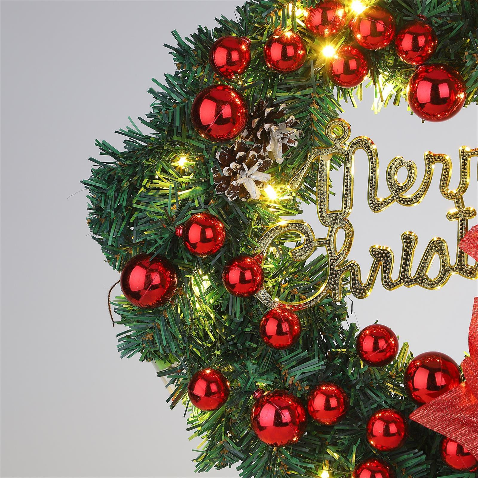 Ein Weihnachtskranz mit roten Ornamenten, Tannenzapfen und den Worten "Merry Christmas."