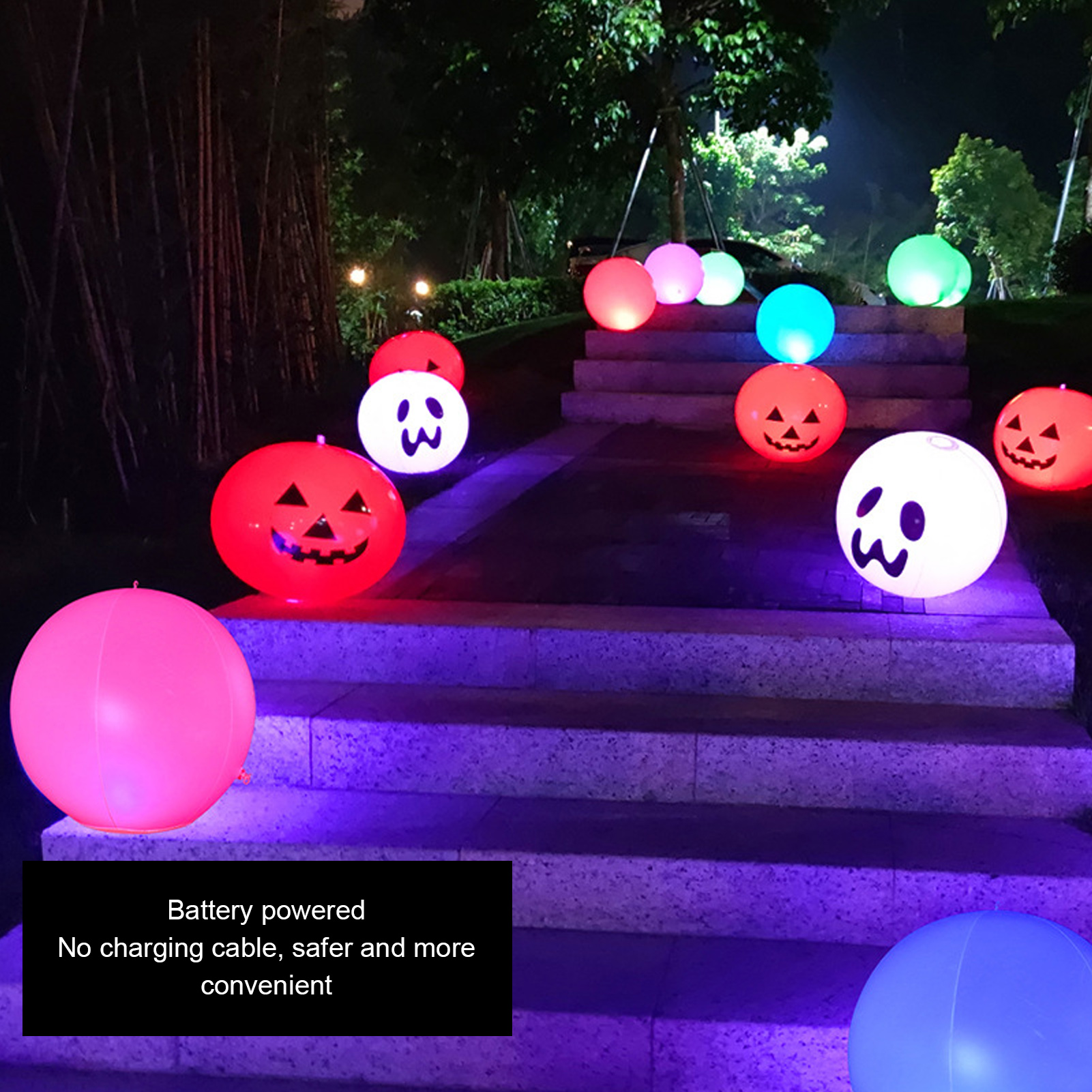 Beleuchtete Halloween-Bälle in verschiedenen Farben auf Stufen bei Nacht. Einige haben Kürbisgesichter und Geistergesichter.