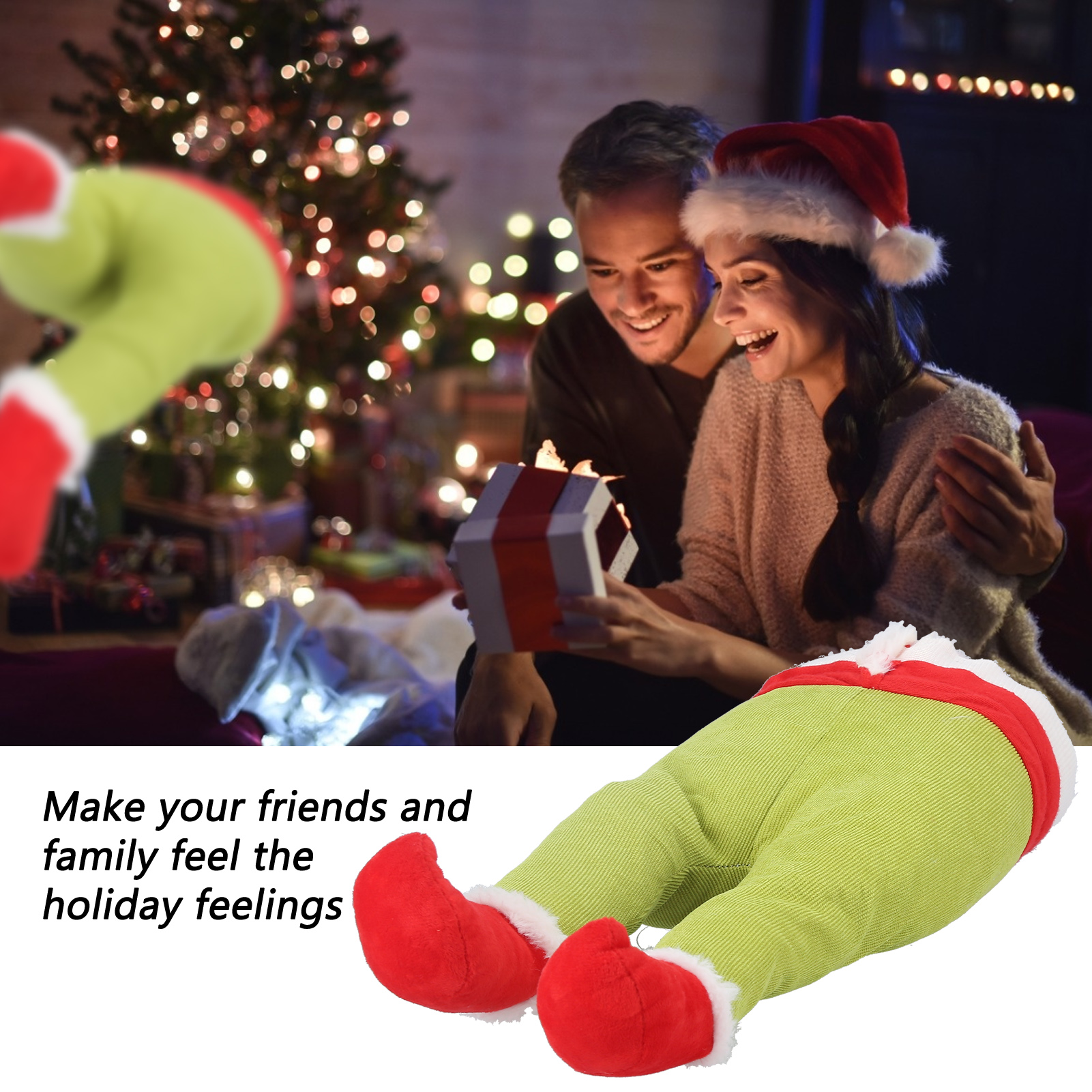 Ein Paar öffnet ein Geschenk vor einem Weihnachtsbaum. Elf-Beine sind im Vordergrund.
