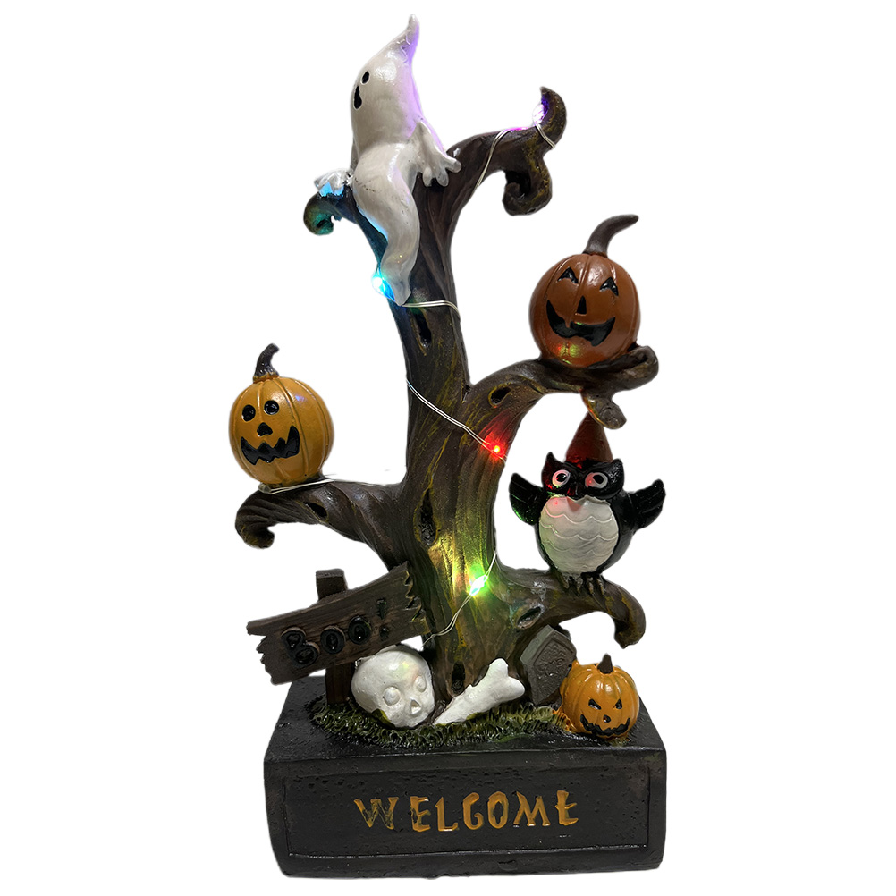 Eine Halloween-Dekoration mit Baum, Kürbissen, Geist, Eule, Schädel und 'Willkommen'-Schild. Der Baum hat Lichter.