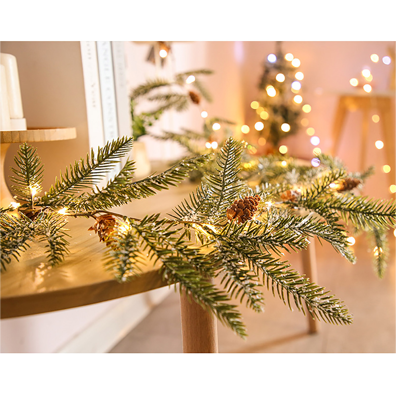Nahaufnahme einer Weihnachtsguirlande mit Tannenzapfen und Lichtern auf einer Holzoberfläche. Im Hintergrund sanfte Lichter.