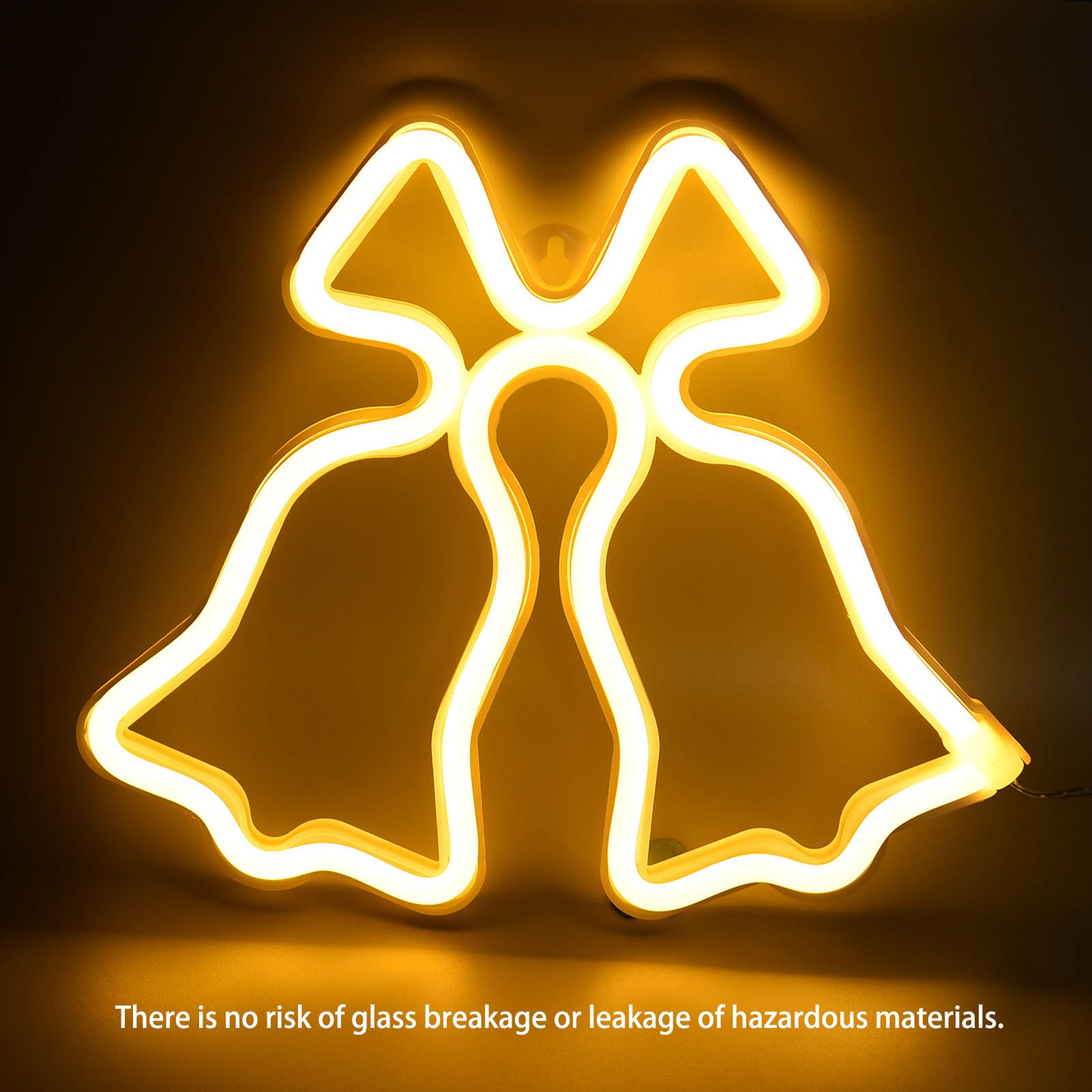 Ein Neonschild in Form von Glocken mit einer Schleife oben leuchtet warm gelb vor dunklem Hintergrund.