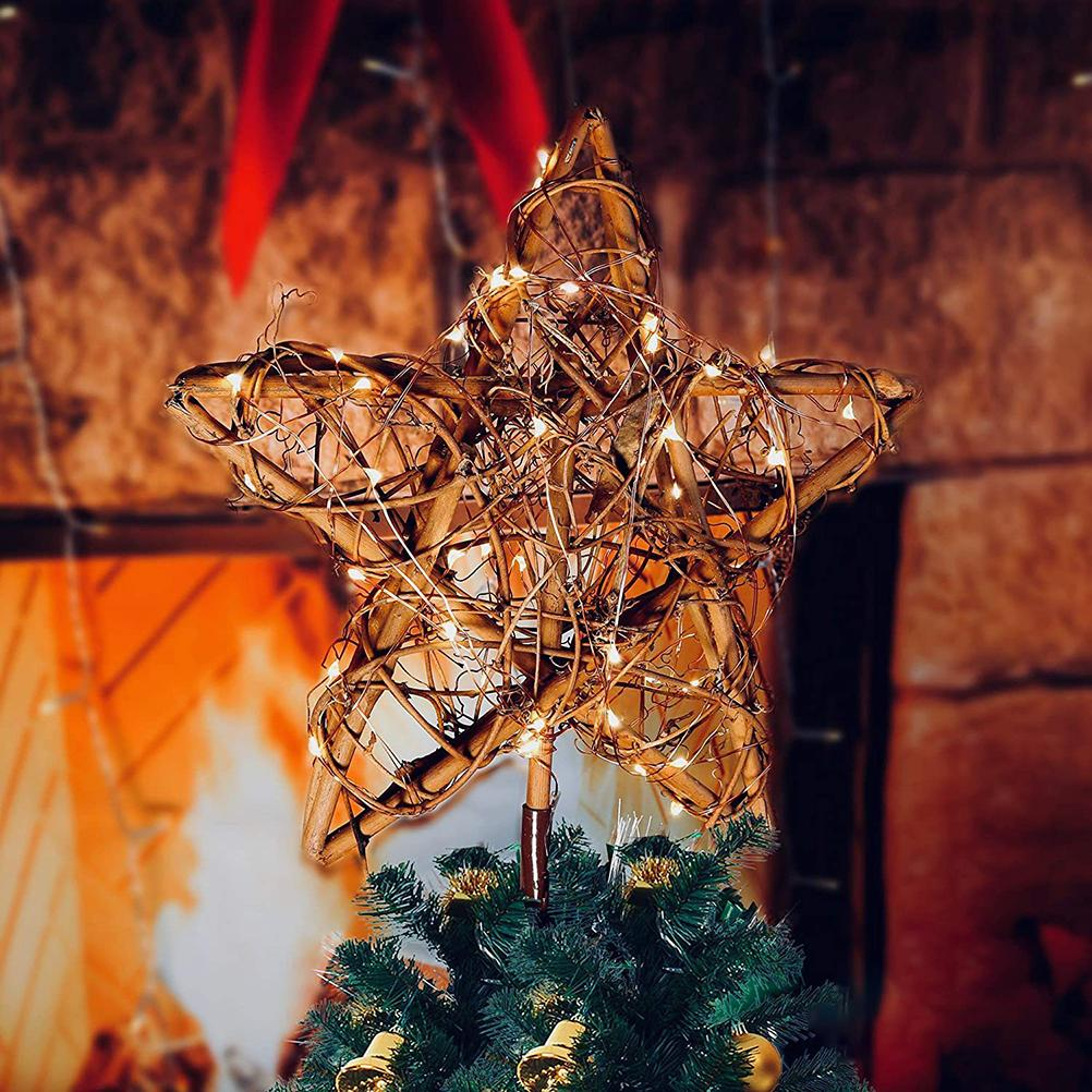 Ein sternförmiger Weihnachtsbaumaufsatz aus verflochtenen Zweigen, der mit kleinen Lichtern beleuchtet ist, auf einem grünen Baum. Im Hintergrund ist ein Kamin.