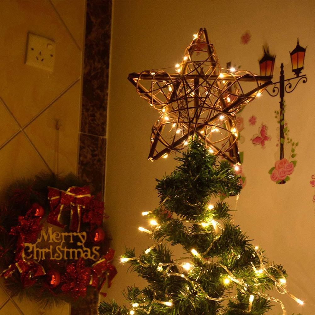 Ein geschmückter Weihnachtsbaum mit Stern, Kranz und Wanddekorationen. Warmes Licht erhellt die Szene.