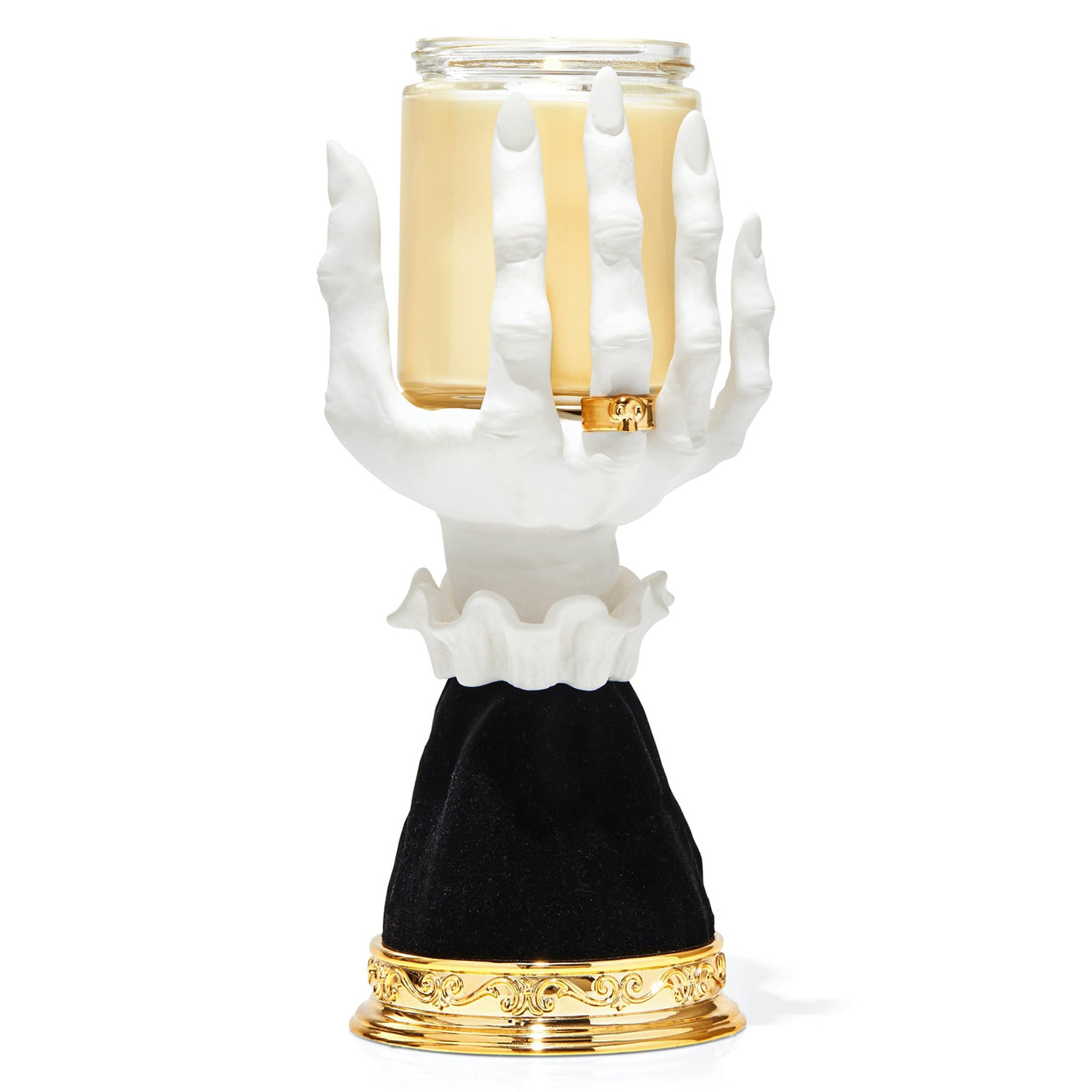 Ein weißer handförmiger Kerzenhalter hält eine Glasbehälterkerze. Ein goldener Ring mit Totenkopf befindet sich am Mittelfinger.