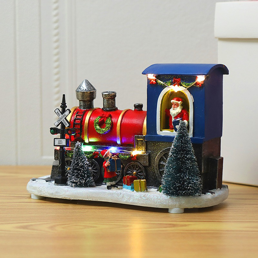 Eine Weihnachtsdekoration in Form eines Zuges mit Santa im Motorraum. Er hat einen roten Waggon, eine blaue Lokführerkanzel und einen kleinen Weihnachtsbaum.