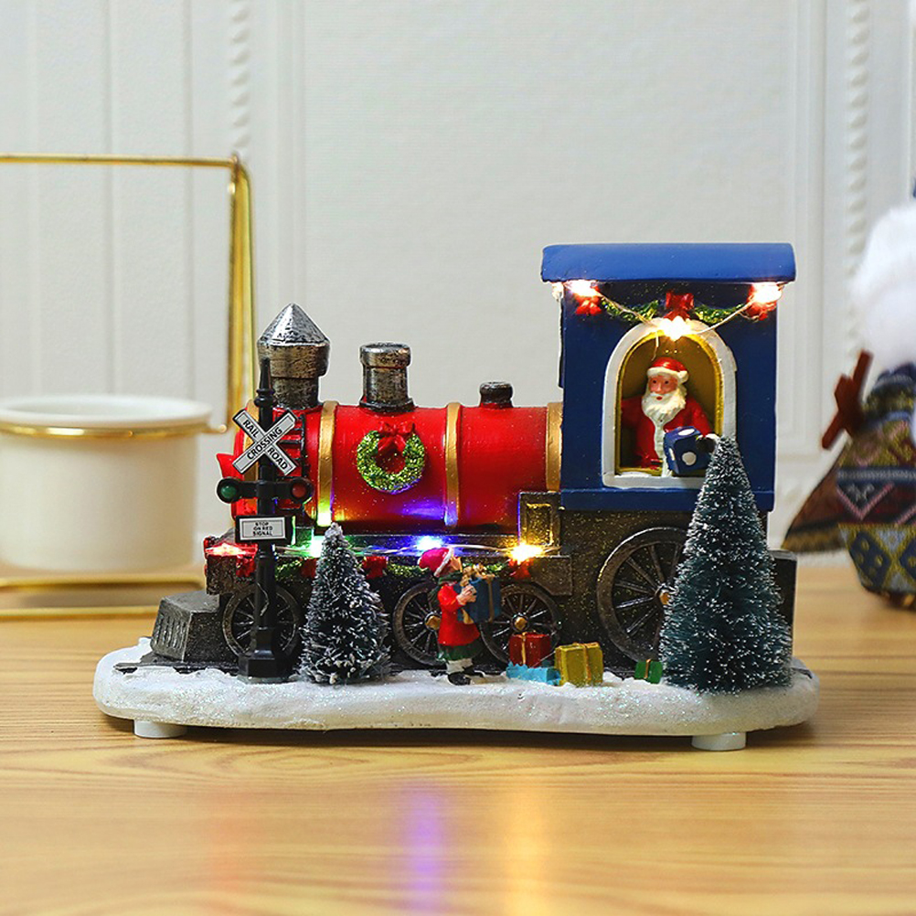 Weihnachtszugdekoration mit Weihnachtsmann in der Kabine, einem Kranz, kleinen Bäumen und einem Bahnübergangsschild.
