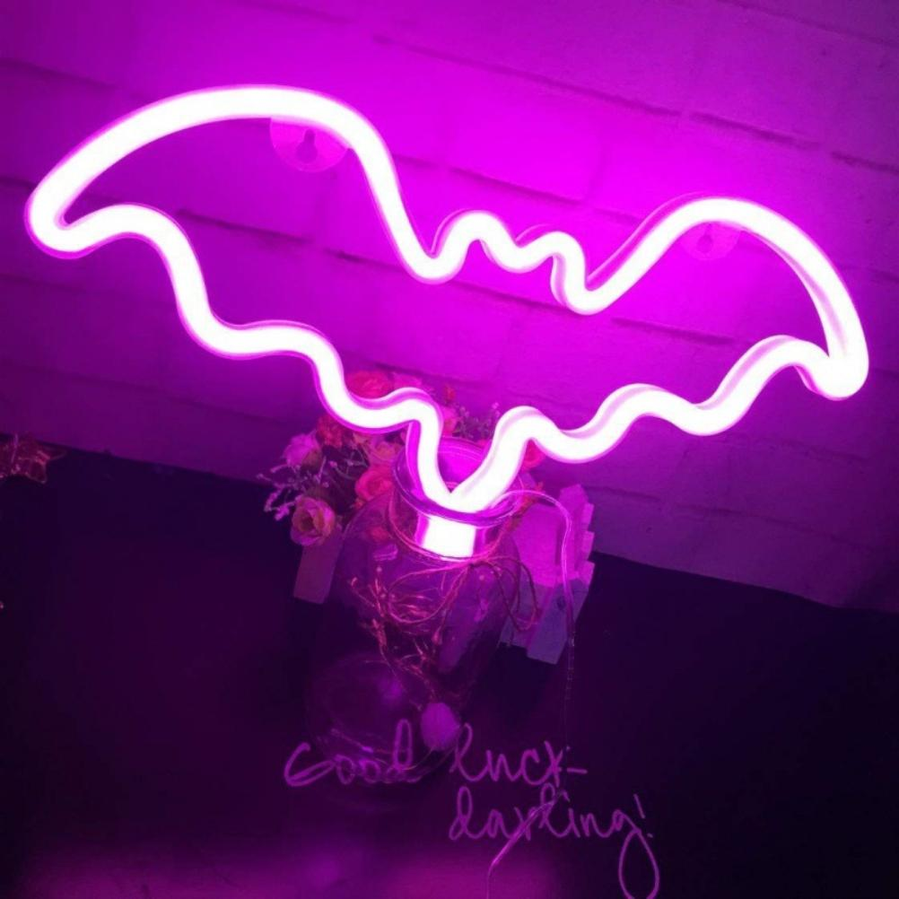 Ein leuchtendes Neon-Fledermausschild. Darunter ein Glas mit Blumen und Lichterketten. Text 'Good luck darling!' ist unten.