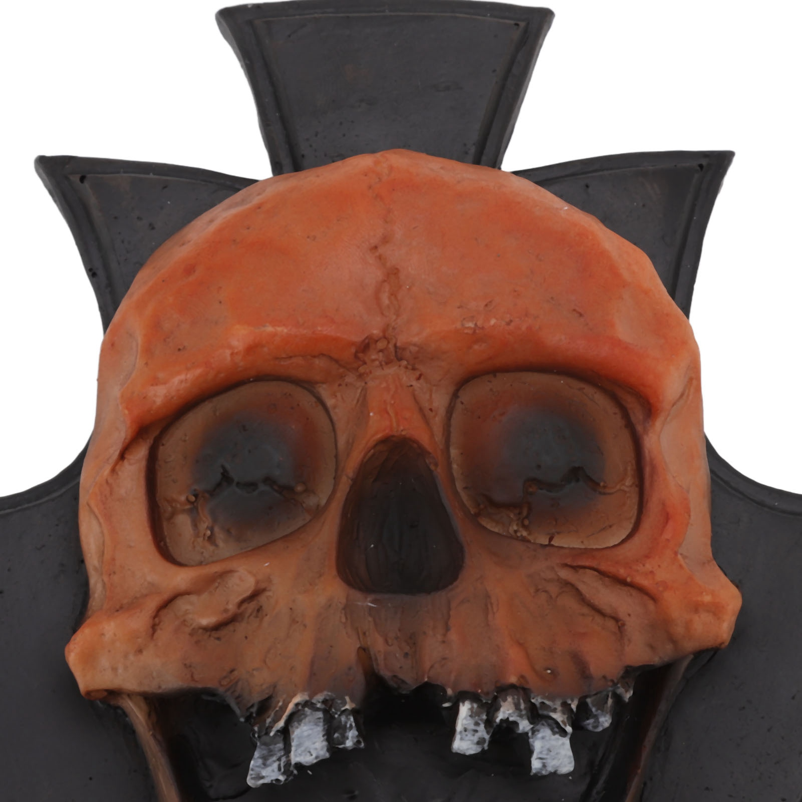 Nahaufnahme einer Halloween-Dekoration. Es ist ein orangefarbener Totenkopf mit schwarzem, kreuzförmigem Hintergrund.