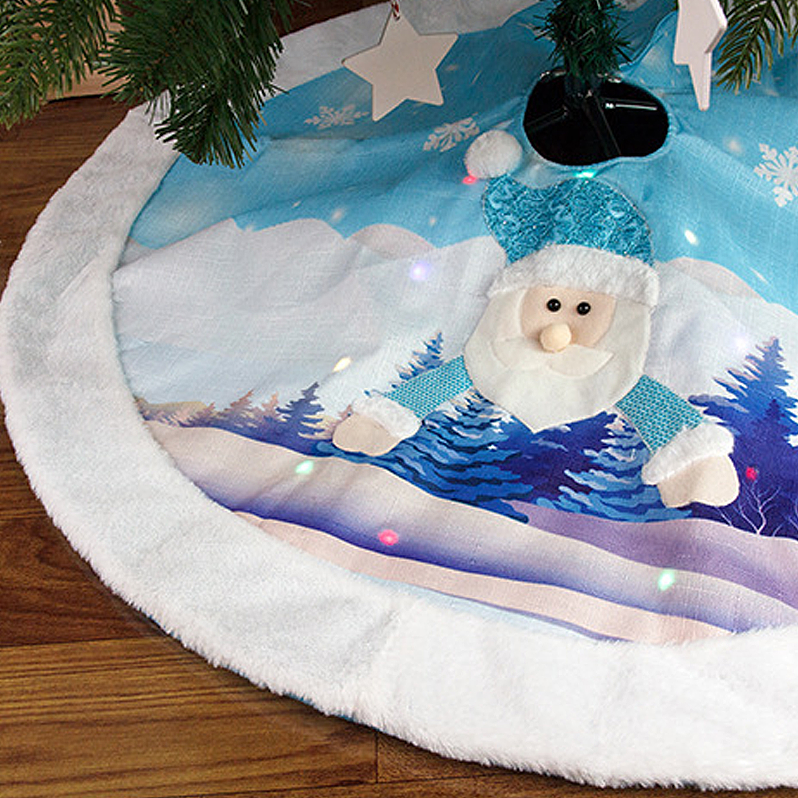 Ein Weihnachtsbaumrock mit einem Weihnachtsmann-Design. Er ist blau und weiß mit einer verschneiten Landschaft und einem flauschigen weißen Rand.