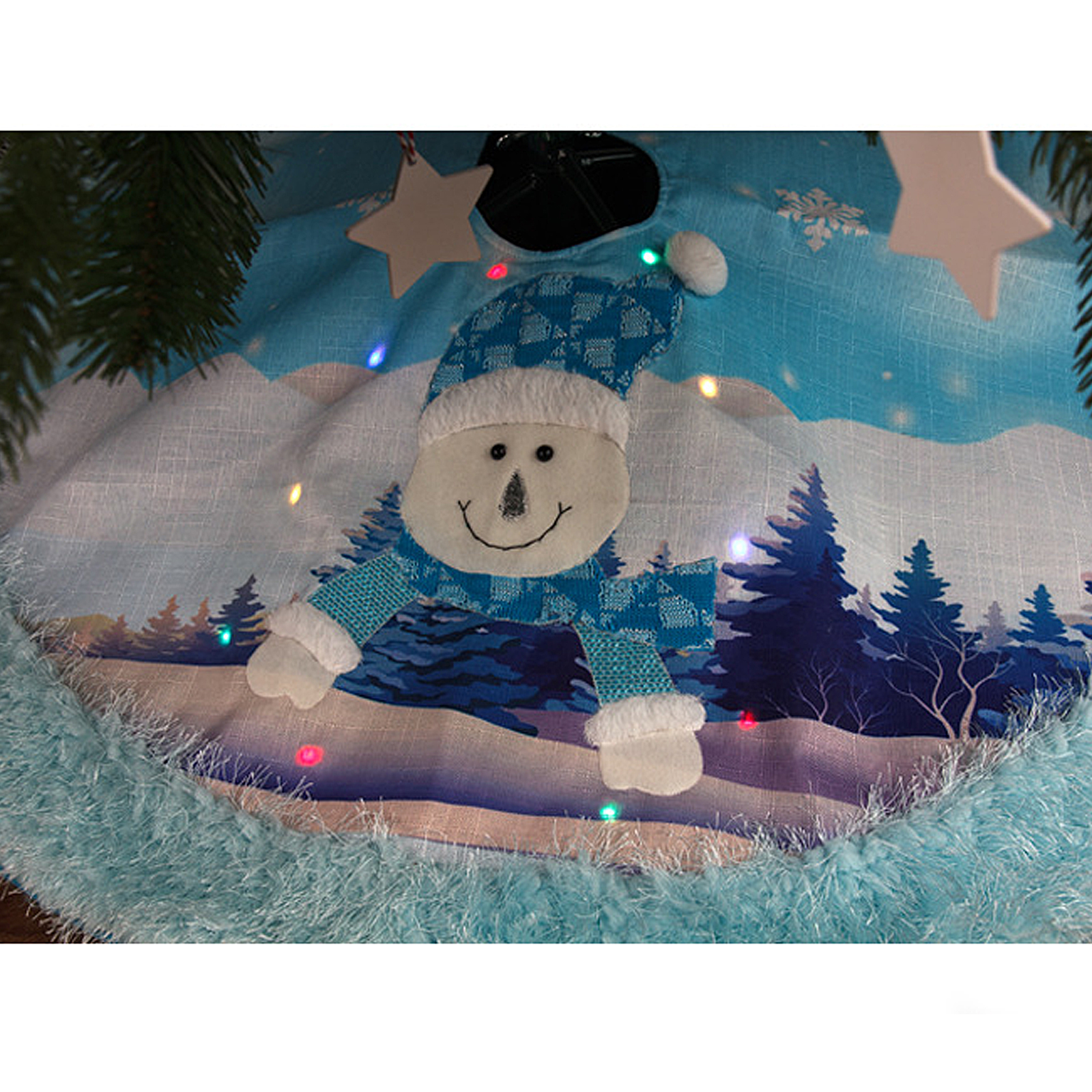 Ein Weihnachtsbaumrock mit einem Schneemann-Design. Es hat einen blauen Hintergrund mit einer Winterlandschaft. Der Rock hat Lichterketten.