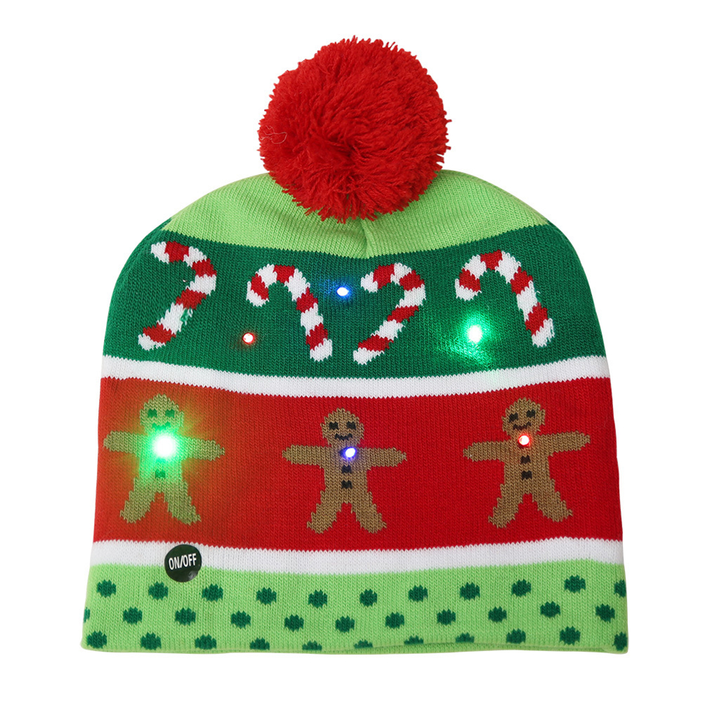 Eine Weihnachtsmütze mit Zuckerstangen, Lebkuchenmännern und einem roten Bommel. Sie hat grüne und rote Streifen mit LED-Leuchten.