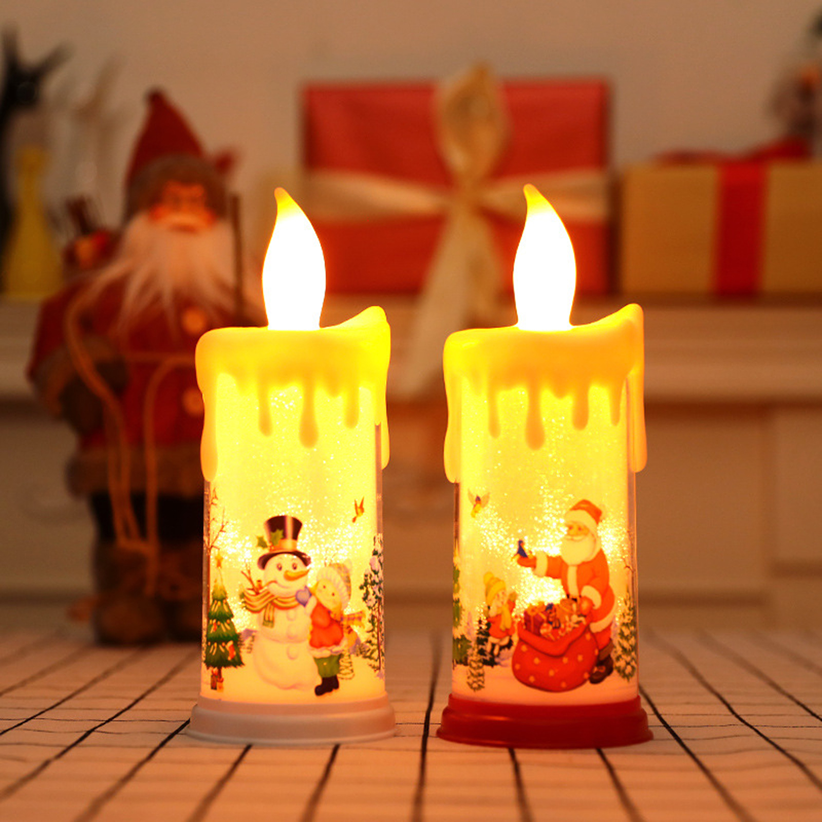 Zwei Weihnachtskerzen mit Santa- und Schneemann-Illustrationen. Hintergrund: Geschenke und eine Weihnachtsmannfigur.