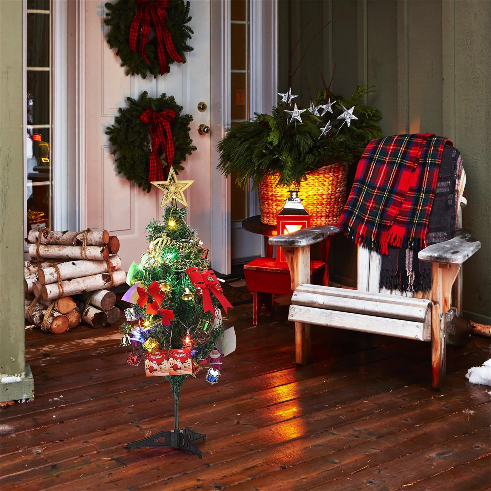 Weihnachtliche Veranda. Baum, Kränze, Stuhl mit Decke, Holzscheite und Laterne. Festliche Dekorationen.
