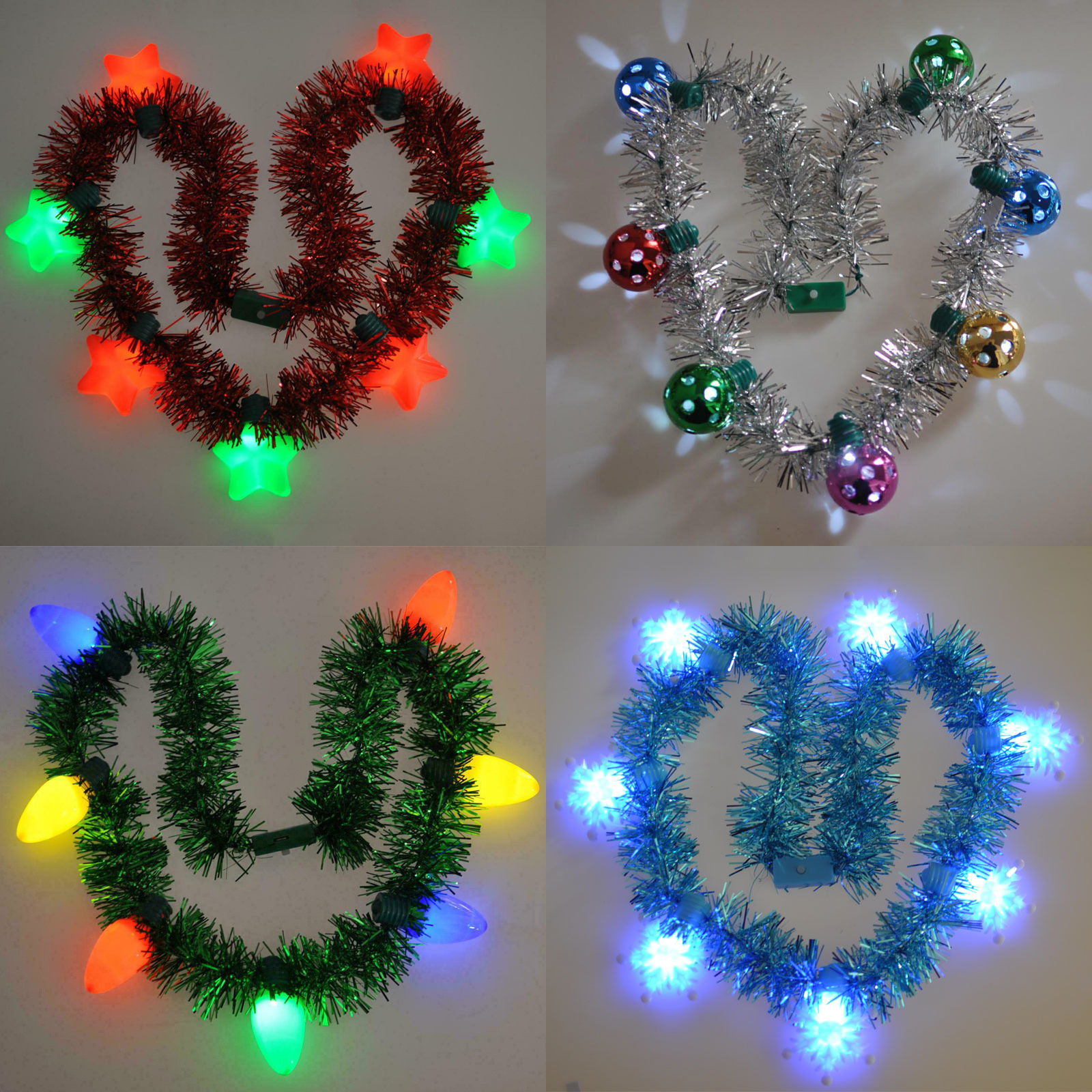 Vier herzförmige Weihnachtslichter. Rotes Lametta mit Sternlichtern, silbernes Lametta mit runden Lichtern, grün mit Glühlampen, blau mit Sternlichtern.