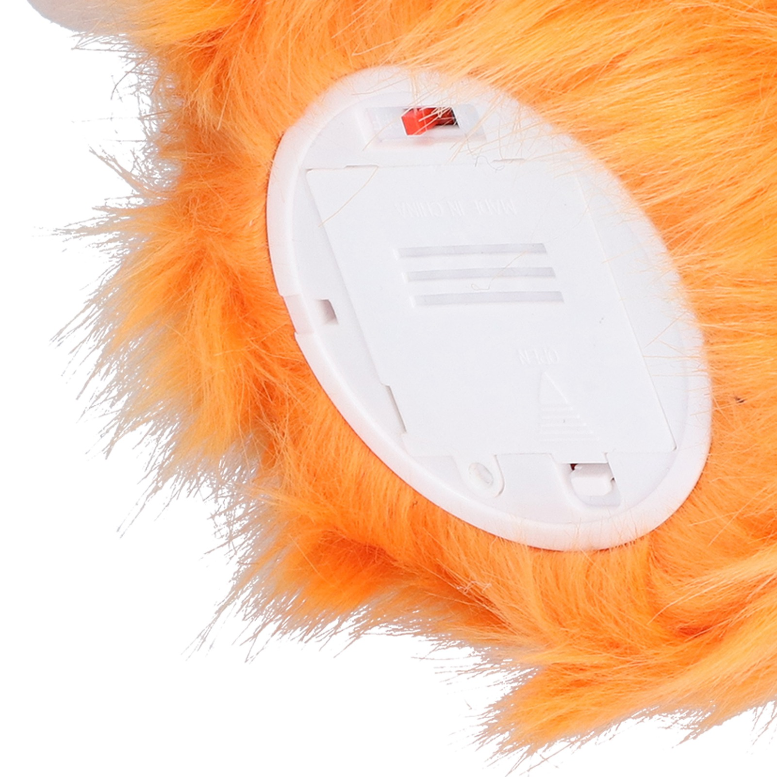 Nahaufnahme von orangefarbenem Plüschfell und einem weißen Batteriefach mit rotem Schalter. Weißer Hintergrund.