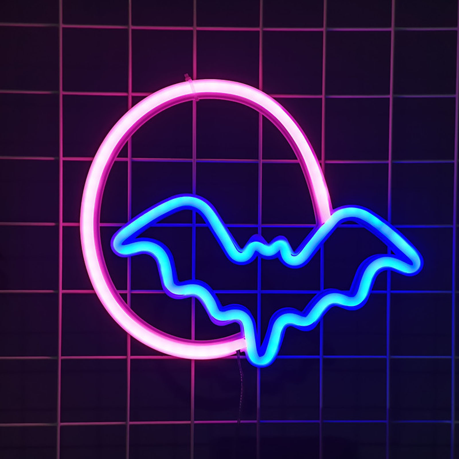 Neonschild mit einem rosa Kreis und einer blauen Fledermausform auf kariertem Hintergrund. Farben sind Pink, Blau und Lila.