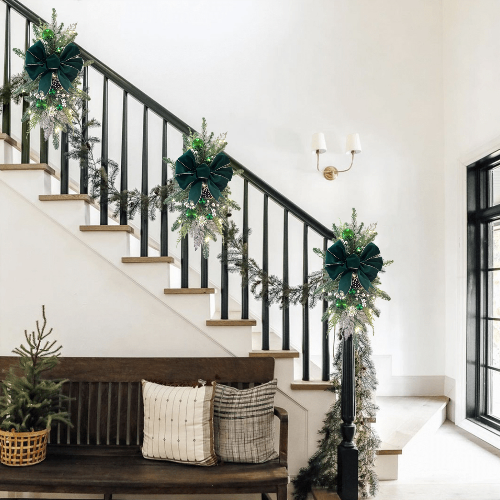 Eine Treppe, die zu Weihnachten mit Girlanden, Schleifen und einer Bank mit Kissen geschmückt ist. Ein kleiner Weihnachtsbaum im Korb.