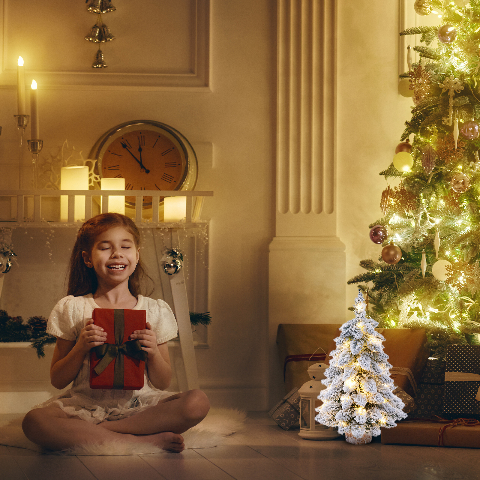 Ein Mädchen sitzt und hält ein Geschenk. Hinter ihr steht ein Weihnachtsbaum. Im Raum befinden sich Kerzen und eine Uhr.